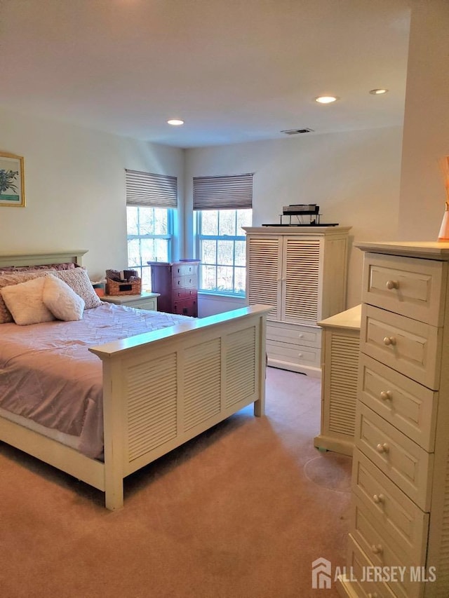 bedroom featuring recessed lighting, light colored carpet, and visible vents