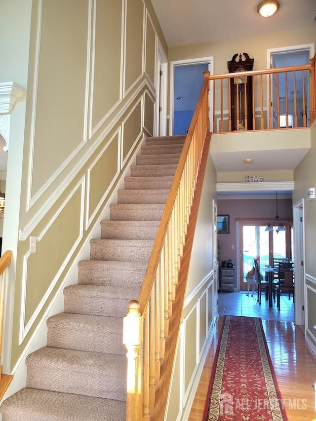 stairs with a decorative wall and wood finished floors