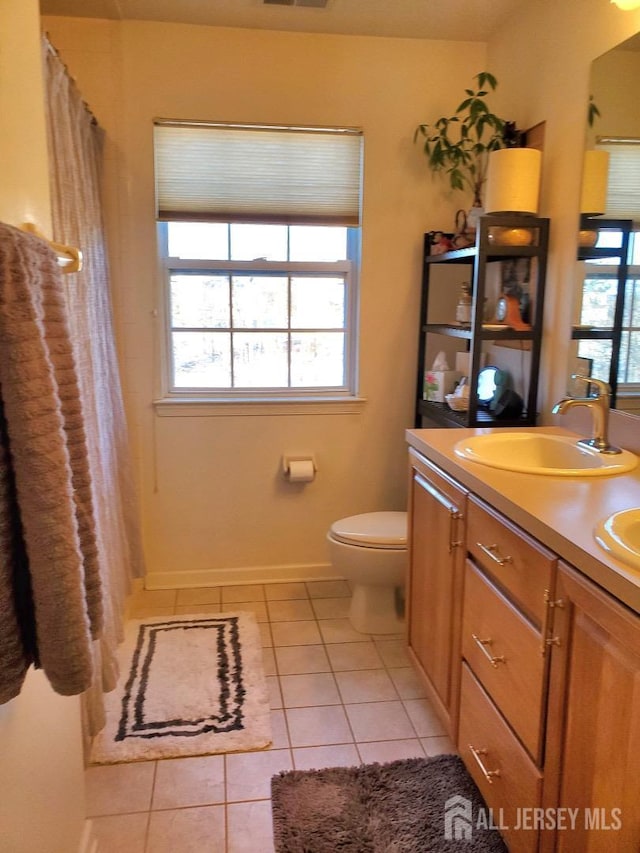 full bath featuring a sink, plenty of natural light, toilet, and tile patterned floors