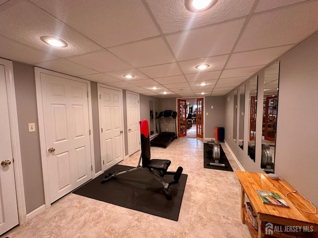exercise room with recessed lighting, baseboards, and a drop ceiling