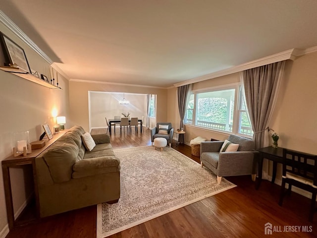 living area with baseboards, ornamental molding, dark wood finished floors, and a chandelier