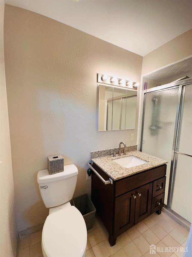 full bath featuring vanity, toilet, tile patterned floors, and a stall shower