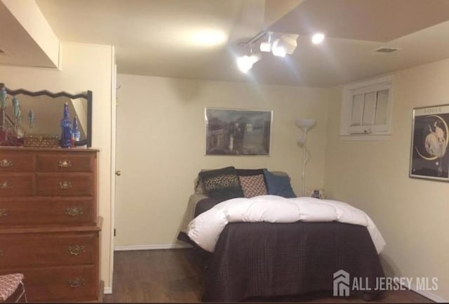 bedroom featuring baseboards and wood finished floors