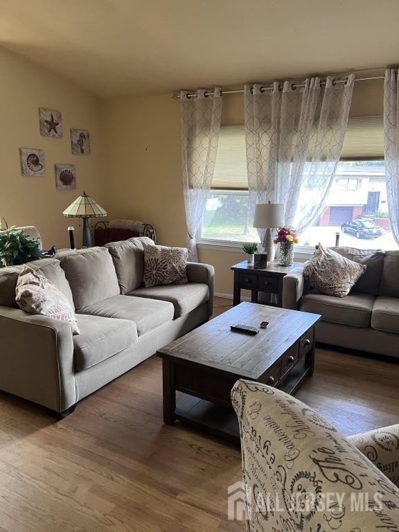 living area with lofted ceiling and wood finished floors