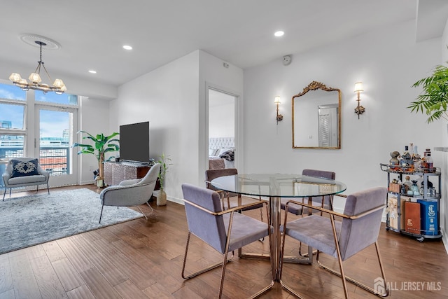 dining room featuring baseboards, an inviting chandelier, wood finished floors, and recessed lighting