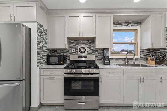 kitchen featuring white cabinetry, sink, appliances with stainless steel finishes, and tasteful backsplash