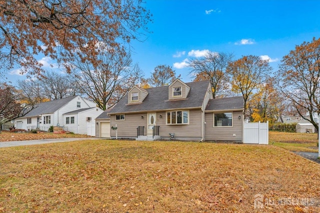 cape cod home with a front yard, fence, and driveway