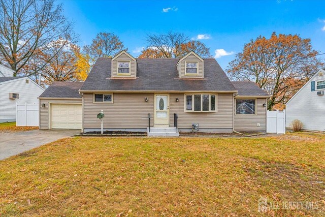 cape cod home featuring a garage and a front lawn