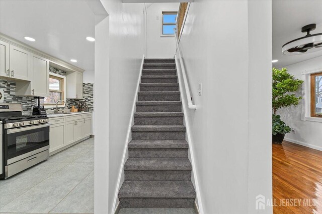 stairs with sink and wood-type flooring