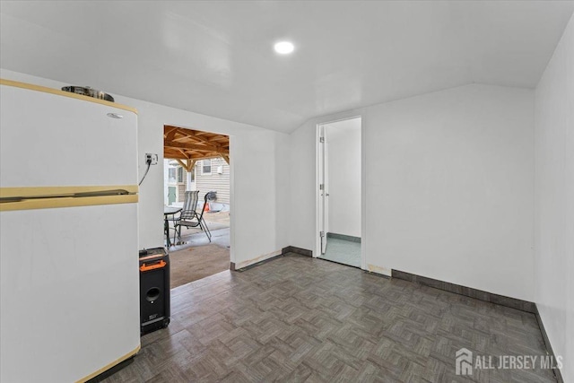 spare room with dark parquet flooring and lofted ceiling