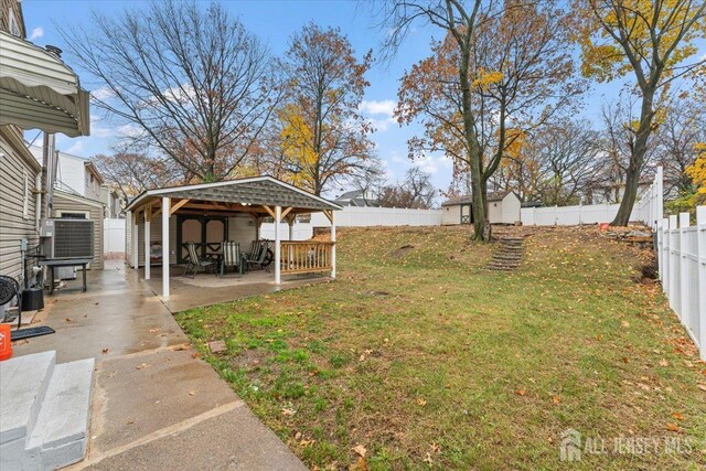 view of yard featuring a storage shed, central air condition unit, and a carport