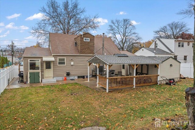 back of property with a yard and a patio