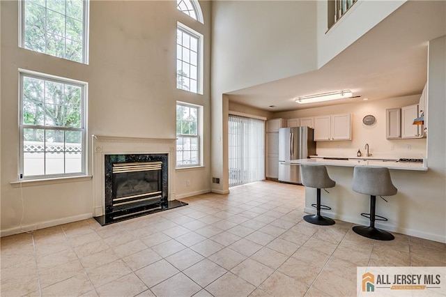 303 Harvest Ln, South Brunswick, NJ 08852 - kitchen with freestanding refrigerator, a towering ceiling, healthy amount of natural light, and light countertops