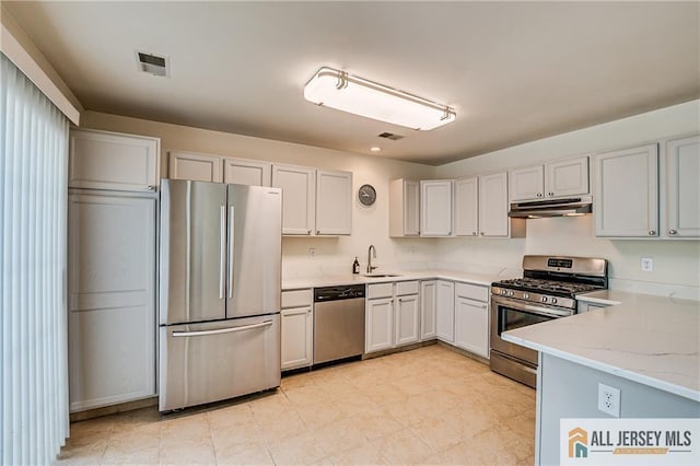 303 Harvest Ln, South Brunswick, NJ 08852 - kitchen featuring appliances with stainless steel finishes, under cabinet range hood, and light stone counters