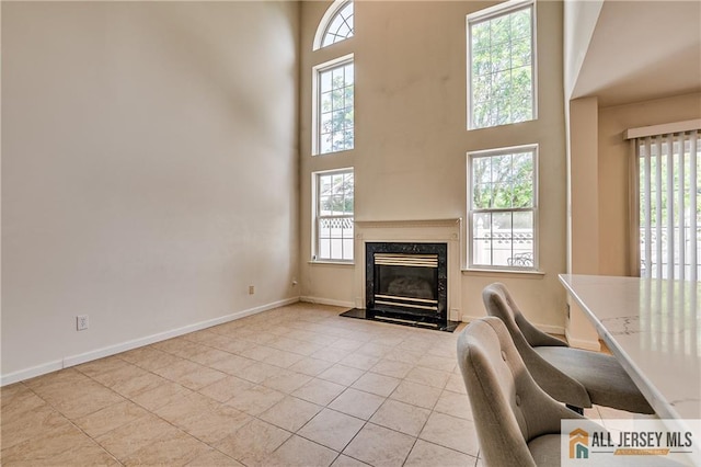 303 Harvest Ln, South Brunswick, NJ 08852 - living area featuring healthy amount of natural light, a towering ceiling, a premium fireplace, and light tile patterned floors