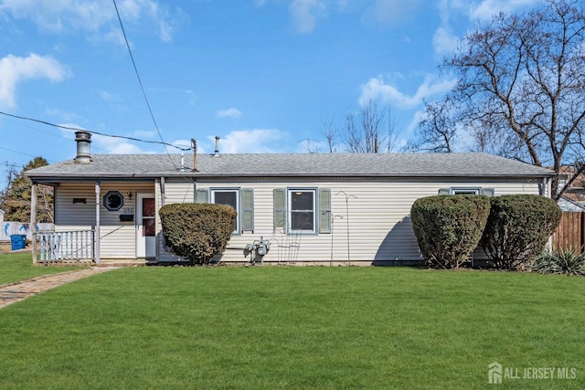 view of front of house featuring a front yard, fence, and roof with shingles