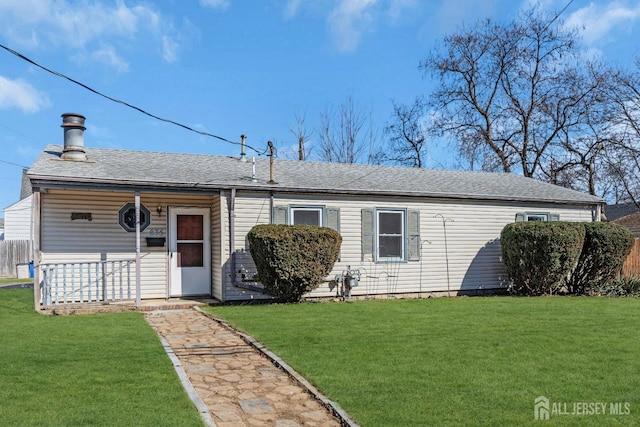 rear view of property with a yard and roof with shingles