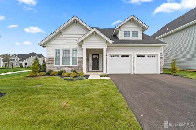 view of front of house featuring stone siding, aphalt driveway, a front lawn, and roof with shingles