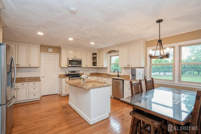 8 Appletree Ln, East Brunswick, NJ 08816 - kitchen with appliances with stainless steel finishes, a sink, light wood-style flooring, a center island, and light stone counters