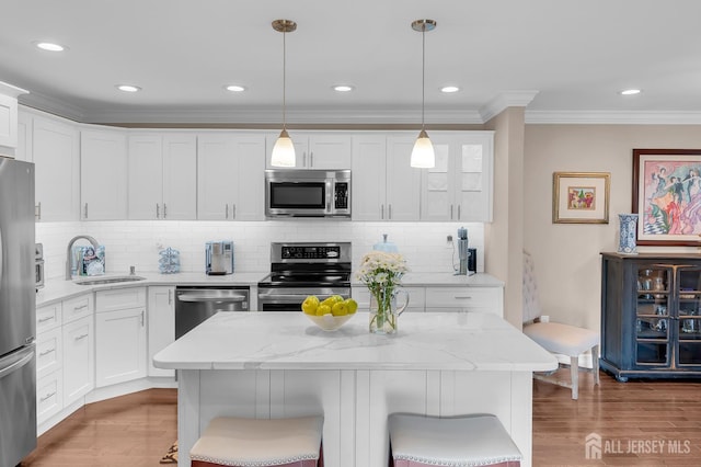 3 William Harrison Dr Unit A, Monroe, NJ 08831 - kitchen featuring appliances with stainless steel finishes, a sink, a breakfast bar, crown molding, and white cabinets
