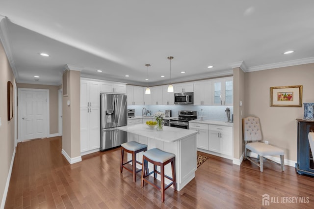 3 William Harrison Dr Unit A, Monroe, NJ 08831 - kitchen with appliances with stainless steel finishes, white cabinetry, a breakfast bar, crown molding, and a sink