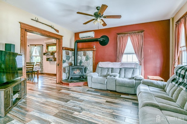 living area featuring wood finished floors, plenty of natural light, and a wall mounted AC