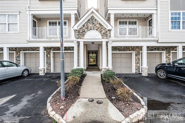 313 Prestwick Way, Edison, NJ 08820 - property entrance with stone siding, a garage, driveway, and a balcony