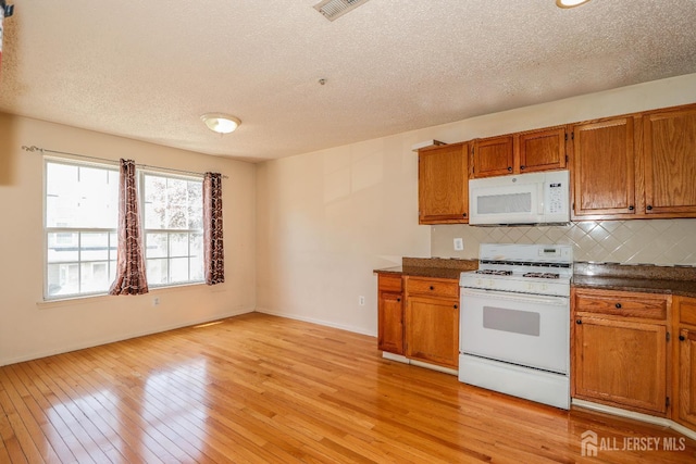 313 Prestwick Way, Edison, NJ 08820 - kitchen with white appliances, brown cabinetry, a textured ceiling, decorative backsplash, and dark countertops