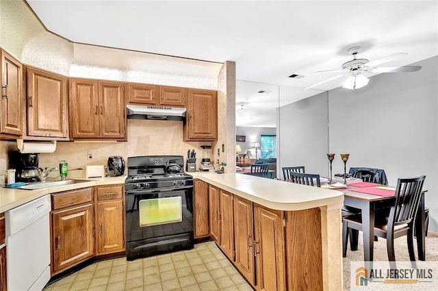 127 Pennsylvania Way N, Brunswick, NJ 08902 - kitchen featuring black range with gas cooktop, dishwasher, under cabinet range hood, a sink, and a peninsula