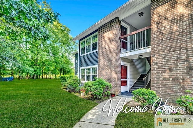 127 Pennsylvania Way N, Brunswick, NJ 08902 - doorway to property with a yard, a balcony, and brick siding