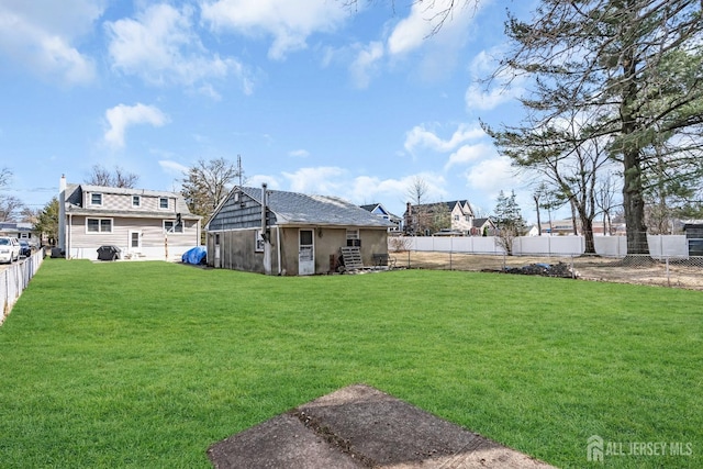 view of yard with a fenced backyard and an outdoor structure