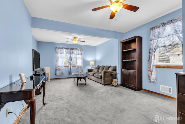 carpeted living area with a ceiling fan, visible vents, and baseboards