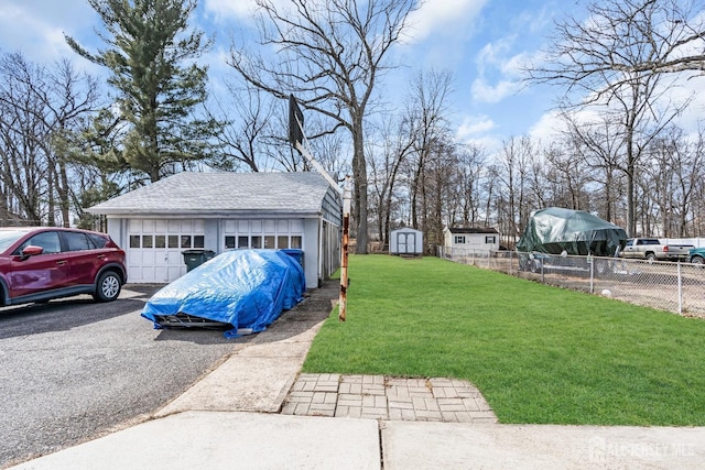 view of yard with an outdoor structure, fence, and a detached garage