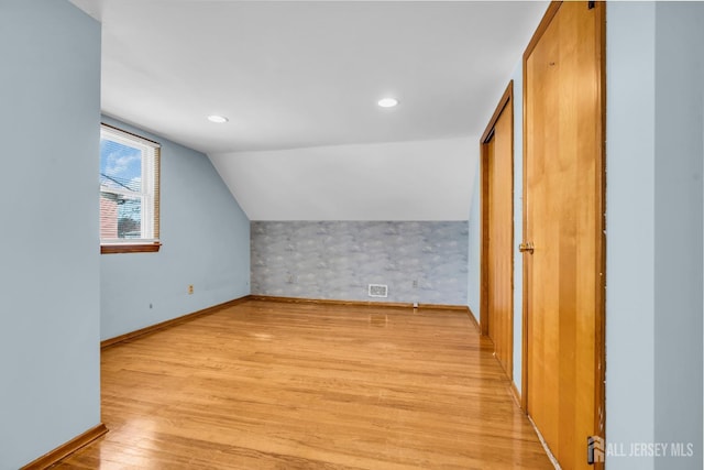 additional living space with light wood finished floors, baseboards, vaulted ceiling, and recessed lighting