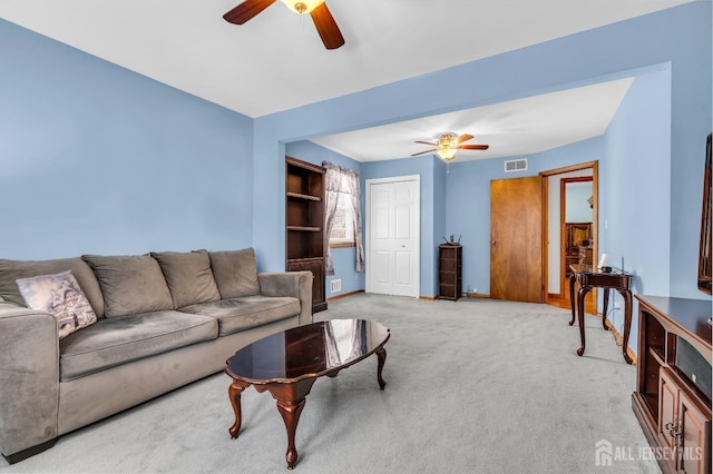 living room with light carpet, baseboards, visible vents, and a ceiling fan