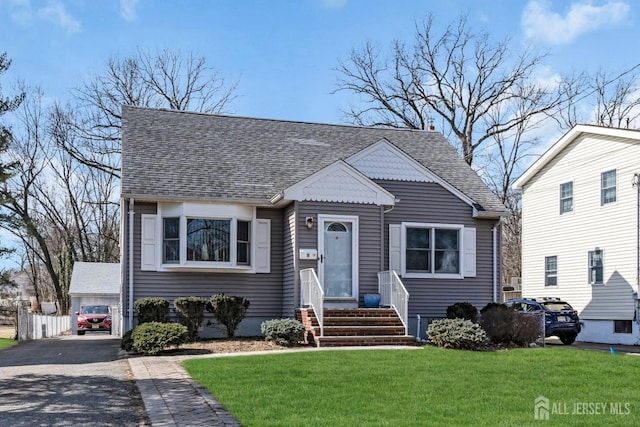 bungalow-style home featuring a shingled roof and a front lawn