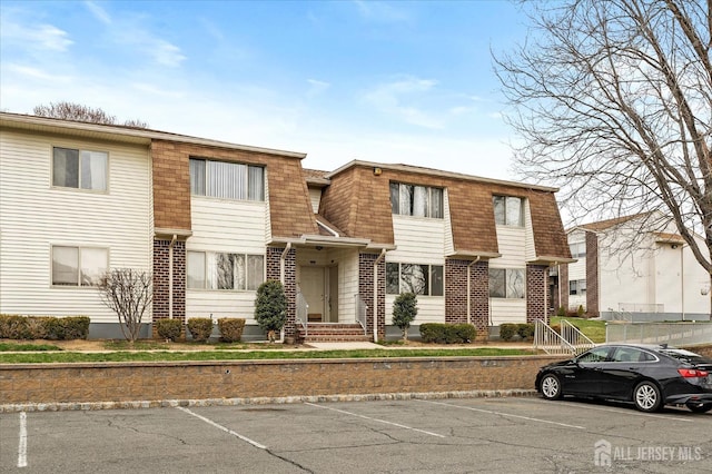511 Bradley Ct, South Brunswick, NJ 08540 - view of property featuring roof with shingles, mansard roof, brick siding, entry steps, and uncovered parking