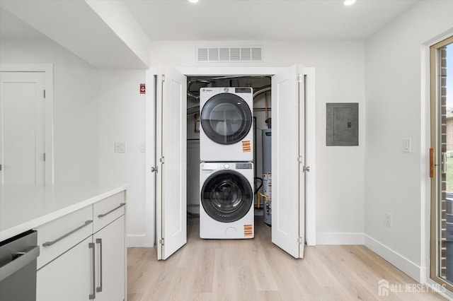 511 Bradley Ct, South Brunswick, NJ 08540 - laundry area featuring electric panel, light wood-type flooring, visible vents, stacked washer and dryer, and laundry area