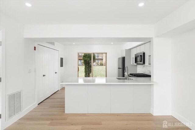 511 Bradley Ct, South Brunswick, NJ 08540 - kitchen with recessed lighting, stainless steel appliances, visible vents, a sink, and a peninsula