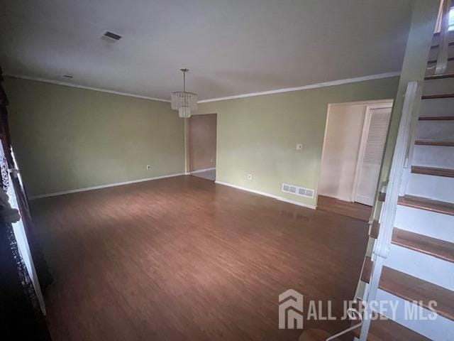 spare room featuring ornamental molding and dark hardwood / wood-style flooring