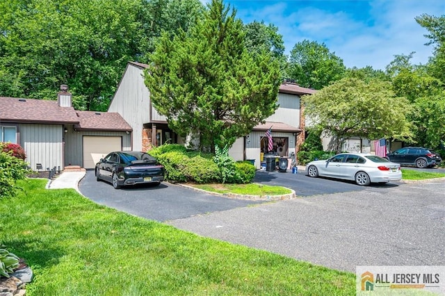 76 Letts Ct Unit 167, Old Bridge, NJ 07747 - view of front of home featuring an attached garage, driveway, a front lawn, and a chimney