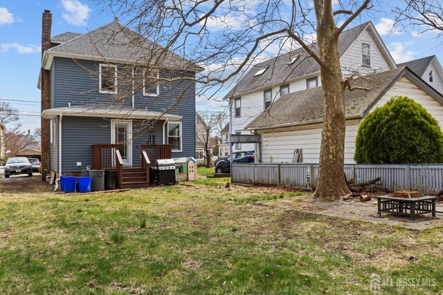 31 Riva Ave, Milltown, NJ 08850 - rear view of house featuring an outdoor fire pit, a chimney, and roof with shingles