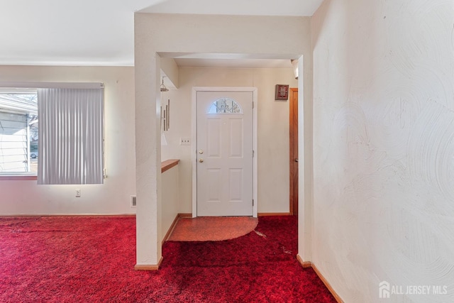 carpeted entrance foyer featuring baseboards