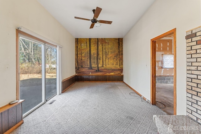 spare room featuring light carpet, ceiling fan, and visible vents