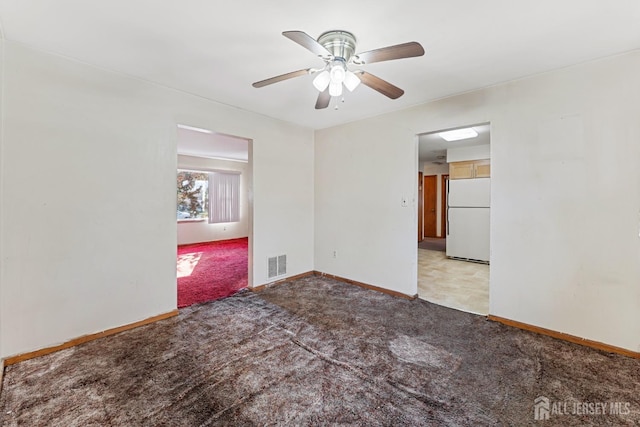 unfurnished room with visible vents, ceiling fan, light carpet, and baseboards