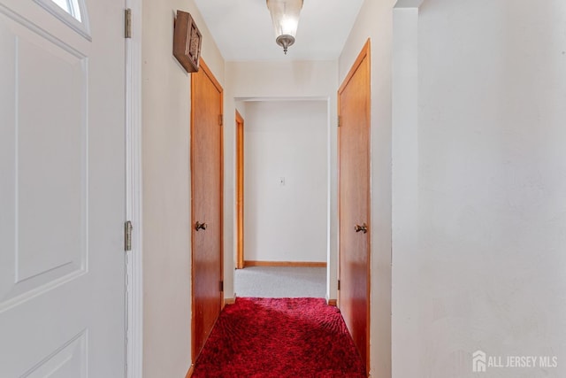 corridor featuring carpet and baseboards