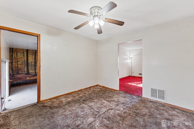 spare room with carpet, visible vents, and baseboards