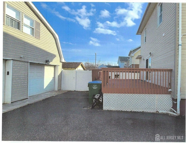 307 Poll Pl, Edison, NJ 08817 - view of patio featuring a wooden deck, a garage, and asphalt driveway