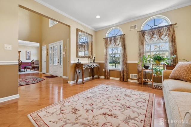 interior space featuring hardwood / wood-style flooring, a wealth of natural light, and crown molding