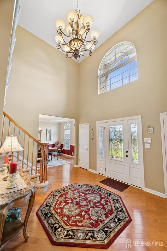 foyer entrance featuring a notable chandelier, a high ceiling, and hardwood / wood-style floors